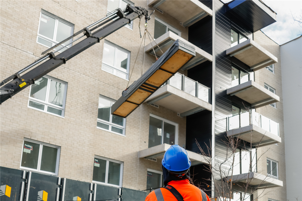 Photo Intermat d’un chantier de construction de condos montrant la structure du bâtiment et les ouvertures de portes, illustrant la division 8 en construction et la finition intérieure.